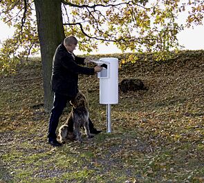 Beutel entnehmen, Hundekot mit umgestülptem Beutel aufnehmen und zuknoten