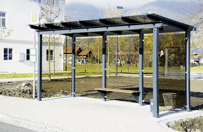 Wartehalle PEGASUS, Dachbreite x Dachtiefe 4800 mm x 2000 mm, auftragsbezogene Anpasssung Verglasung bronce, mit Sitzbank ARES und Abfallbehälter BRITS, Stahlkonstruktion in RAL 703 eisenglimmer