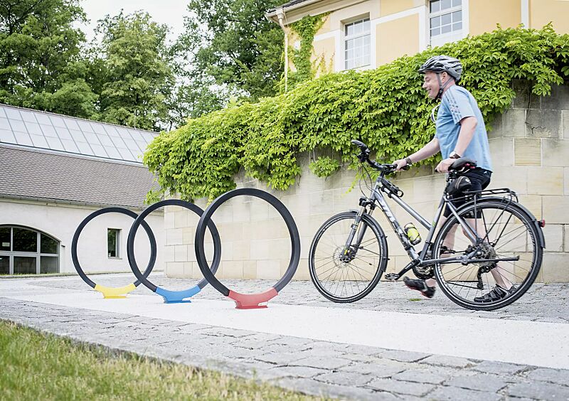 Anlehnbügel GOMEZ, Aluminiumfußabdeckung in RAL 1021 rapsgelb, RAL 5019 capriblau und RAL 3020 verkehrsrot