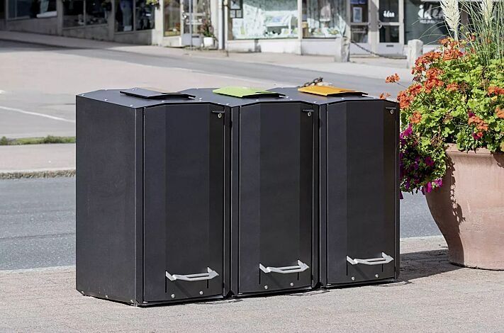 Abfallbehälter EKOCITY, Einwurfklappe in RAL 7021 schwarzgrau, RAL 6018 gelbgrün, RAL 1028 melonengelb, Stahlteile in Finbin Black 1945, ähnl. schwarz metallic, strukturiert