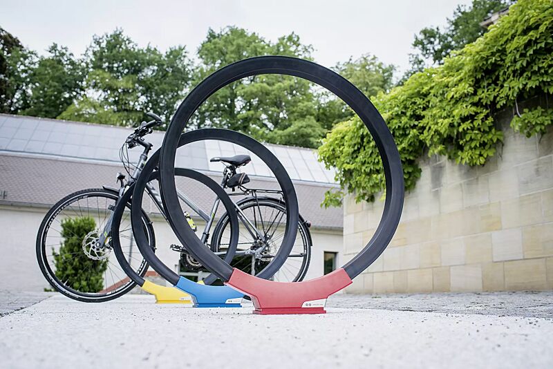 anlehnbuegel-gomez__shoKAT0057834 Anlehnbügel GOMEZ, Aluminiumfußabdeckung in RAL 1021 rapsgelb, RAL 5019 capriblau und RAL 3020 verkehrsrot