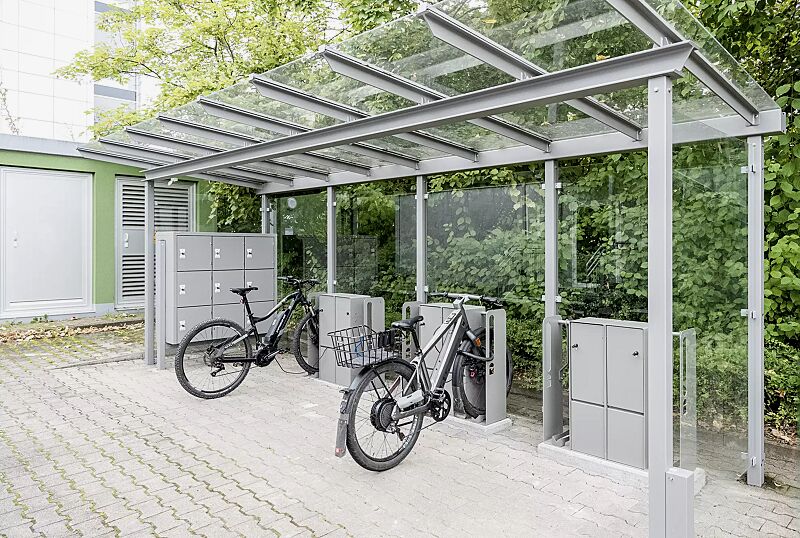 fahrrad-abstellanlage-velo-connector__shoKAT0068230 Fahrrad-Abstellanlage VELO-CONNECTOR, Fahrradüberdachung PEGASUS, Dachbreite x Dachtiefe 6300 mm x 2250 mm, Rück-/Seitenwände ESG, Klarglas, LED- Beleuchtung, Schließfachschrank SECURE, Stahlkonstruktion in RAL 9007 graualuminium