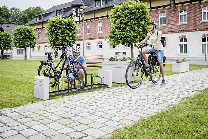 Fahrradständer BRNO, Stahlteile in RAL 7021 schwarzgrau, Beton sandgestrahlt sowie Sitzbank und Pflanzbehälter BRNO
