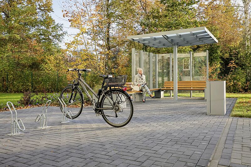 fahrradstaender-hervey__shoKAT0068186 Einzelfahrradständer HERVEY zum Aufdübeln, Meeting-Point PIN, Dachbreite x Dachtiefe 3075 mm x 3075 mm, mit Windschutzwand PIN SCREEN, Sitzbank NATURA, Abfallbehälter LACES, Pflanzbehälter MALOUT, Stahlkonstruktion in RAL 7046 telegrau