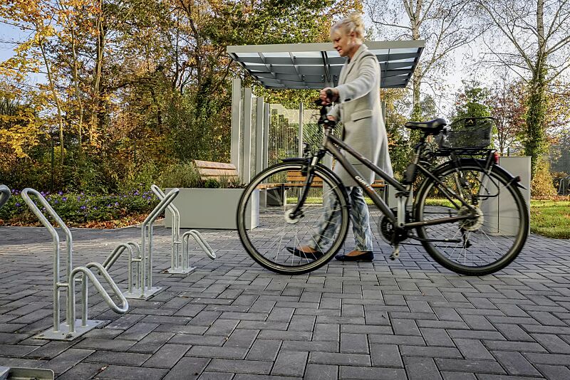 fahrradstaender-hervey__shoKAT0068188 Einzelfahrradständer HERVEY zum Aufdübeln, Meeting-Point PIN, Dachbreite x Dachtiefe 3075 mm x 3075 mm, mit Windschutzwand PIN SCREEN, Sitzbank NATURA, Abfallbehälter LACES, Pflanzbehälter MALOUT, Stahlkonstruktion in RAL 7046 telegrau