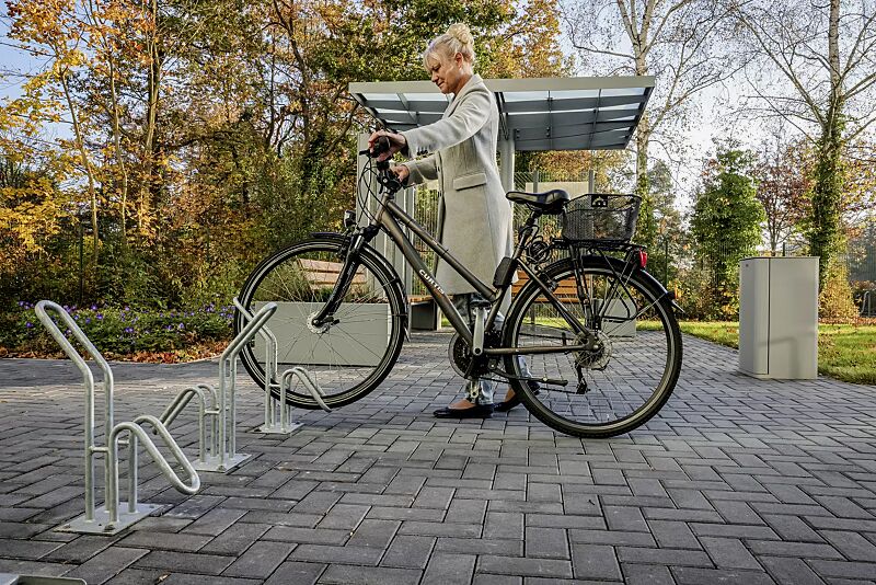 fahrradstaender-hervey__shoKAT0068189 Einzelfahrradständer HERVEY zum Aufdübeln, Meeting-Point PIN, Dachbreite x Dachtiefe 3075 mm x 3075 mm, mit Windschutzwand PIN SCREEN, Sitzbank NATURA, Abfallbehälter LACES, Pflanzbehälter MALOUT, Stahlkonstruktion in RAL 7046 telegrau