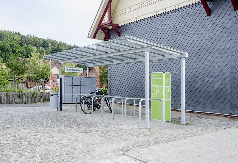 fahrradueberdachung-pegasus__shoKAT0069074 Fahrradüberdachung PEGASUS, Dachbreite x Dachtiefe 12300 mm x 2250 mm, Anlehnbügel MIAMI, Schließfachanlage SECURE mit 12 Schließfächern, E-Bike-Ladestellenschrank AMARO mit 4 kleinen Fächern, Stahlkonstruktion in RAL 7040 fenstergrau bzw. RAL 9017 ver...