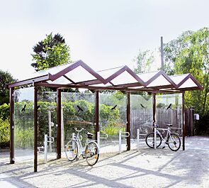 Fahrradüberdachung TANGENTA, einseitig, auftragsbezogene Anpassung mit Unterzug aufgrund erhöhter Schneelast, Dachbreite x Dachtiefe 6200 mm x 2250 mm, Rück- / Seitenwände ESG, Klarglas mit Raubvogelaufkleber, Stahlkonstruktion in RAL 4002 rotviolett