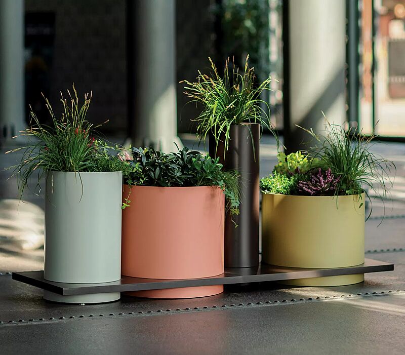 pflanzbehaelter-polys__shoKAT0070669 Pflanzbehälter POLYS mit rechteckiger Plattform, mit vier zylindrischen Behältern in RAL 6019 weißgrün, RAL 2008 hellrotorange, RAL 8019 graubraun und RAL 1020 olivgelb