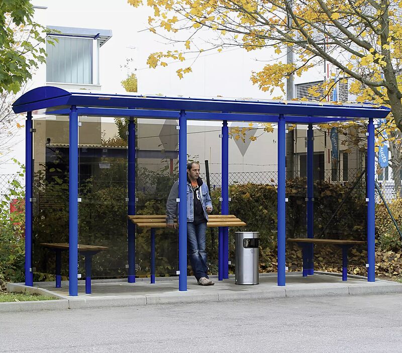 Raucherunterstand PLUTO, Dachbreite x Dachtiefe 4800 mm x 2030 mm, Rück-, Seiten- und Windschutzwänden aus ESG, getönt, Anlehnbank SMOKY, Sitzbank FERMO, Abfallbehälter MANSFIELD, Stahlkonstruktion in RAL 5005 signalblau