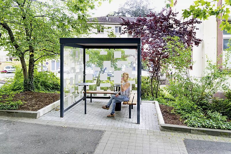 raucherunterstand-tobacco__shoKAT0066294 Raucherunterstand TOBACCO, Dachbreite x Dachtiefe 2400 mm x 2400 mm, mit Rück- / Seitenwänden, zweiseitige Sitzbank TOBACCO, Abfallbehälter / Ascher CALGARY sowie Stehtisch BISTROT, Stahlkonstruktion in RAL 7016 anthrazitgrau, Scheibendekorbeklebung ba...