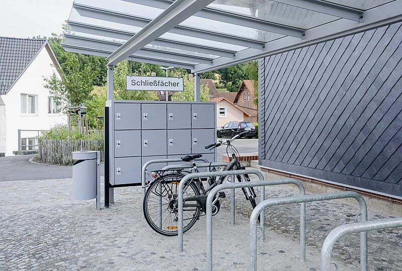 schliessfachanlage-secure__shoKAT0069083 Schließfachanlage SECURE, 12 Schließfächer, Türverriegelung mittels Münzpfandschloss, inklusive Unterzug und Stützen zum Aufdübeln sowie Fahrradüberdachung PEGASUS und Anlehnbügel MIAMI, Stahlkonstruktion in RAL 7040 fenstergrau bzw. RAL 9017 verkehrss...