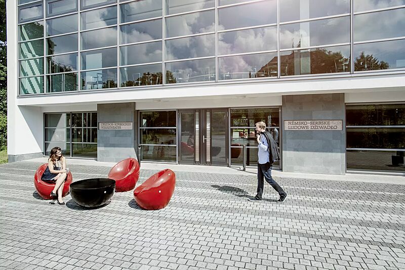 sitz-cuddly__shoKAT0051321 Sitze CUDDLY zum freien Aufstellen, aus Beton, in RAL 3000 feuerrot und Tisch FAMILY zum freien Aufstellen, aus Beton, in RAL 9005 tiefschwarz