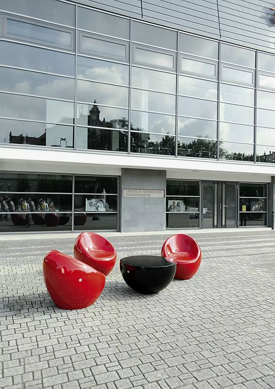 sitz-cuddly__shoKAT0052304 Sitze CUDDLY zum freien Aufstellen, aus Beton, in RAL 3000 feuerrot und Tisch FAMILY zum freien Aufstellen, aus Beton, in RAL 9005 tiefschwarz