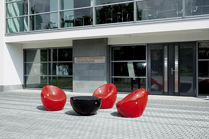 sitz-cuddly__shoKAT0052305 Sitze CUDDLY zum freien Aufstellen, aus Beton, in RAL 3000 feuerrot und Tisch FAMILY zum freien Aufstellen, aus Beton, in RAL 9005 tiefschwarz