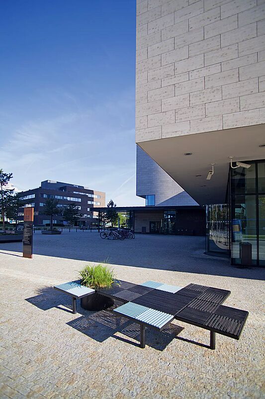 Sitz PIXEL CITÉ, bestehend aus verschiedenen Segmenten, mit Robinienholzbelattung in RAL 5024 pastellblau bzw. RAL 9011 graphitschwarz, Stahlteile in RAL 9011 graphitschwarz