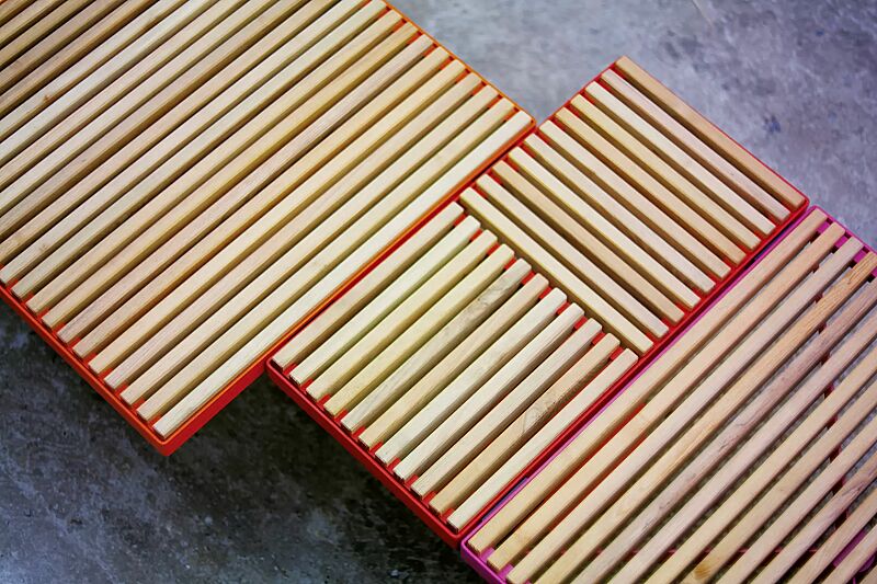 Sitz PIXEL CITÉ, bestehend aus verschiedenen Segmenten, mit Robinienholzbelattung, Stahlteile in RAL 2004 reinorange, RAL 3020 verkehrsrot und RAL 4010 telemagenta