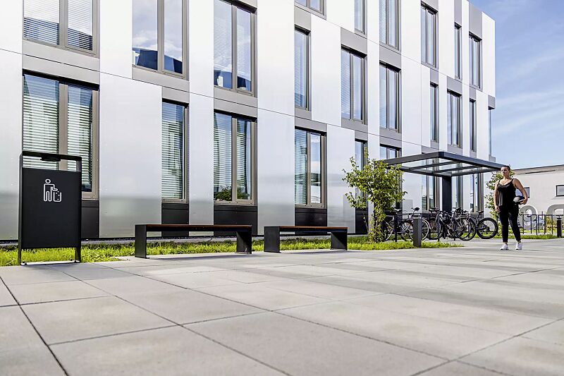 Sitzbank CIMA ohne Rückenlehne, mit Laserschriftzug, mit Hartholzbelattung, Stahlteile in RAL 7016 anthrazitgrau, Abfallbehälter RADIUM sowie Fahrradüberdachung PURE und Anlehnbügel UTAH