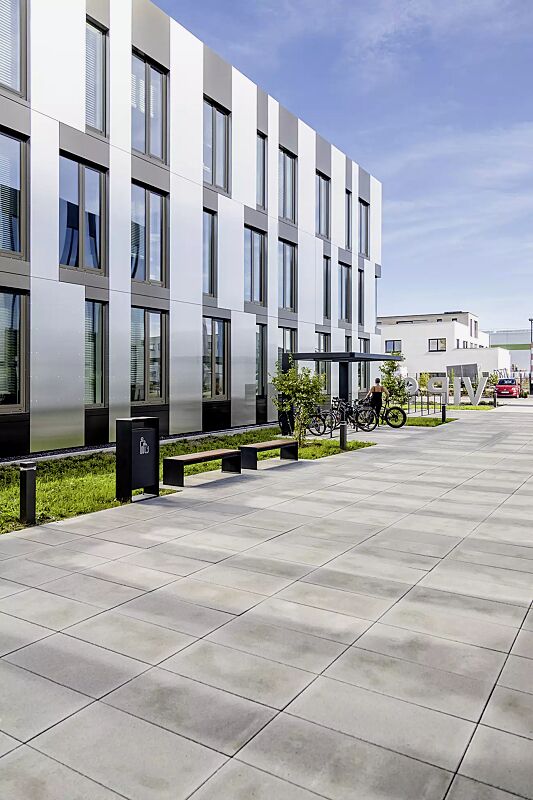 Sitzbank CIMA ohne Rückenlehne, mit Laserschriftzug, mit Hartholzbelattung, Stahlteile in RAL 7016 anthrazitgrau, Abfallbehälter RADIUM sowie Fahrradüberdachung PURE und Anlehnbügel UTAH