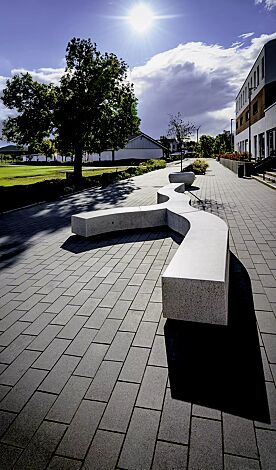 Sitzbank KUBB bestehend aus CROSS KUBB, CURVED KUBB und DOUBLE KUBB, aus Beton, Sitzfläche geschliffen, in Granitoptik weiß sowie Pflanzbehälter GIOVE, Anlehnbügel ELK und Abfallbehälter CIMA