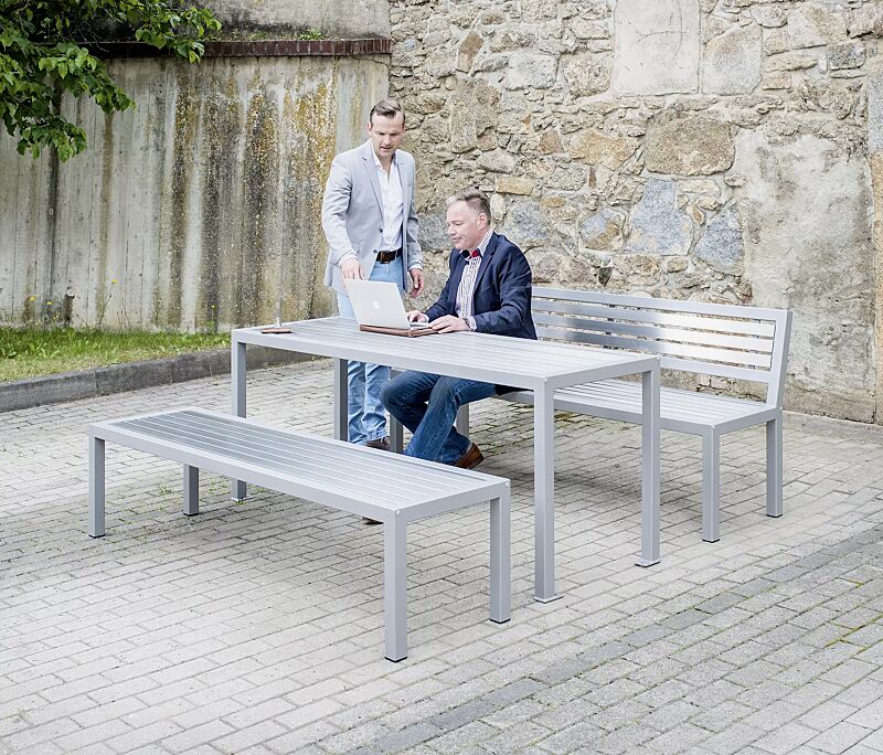 Sitzbank LIGURIA mit und ohne Rückenlehne, zum freien Aufstellen, mit Edelstahlauflage, Stahlgestell in RAL 9007 graualuminium sowie Tisch LIGURIA