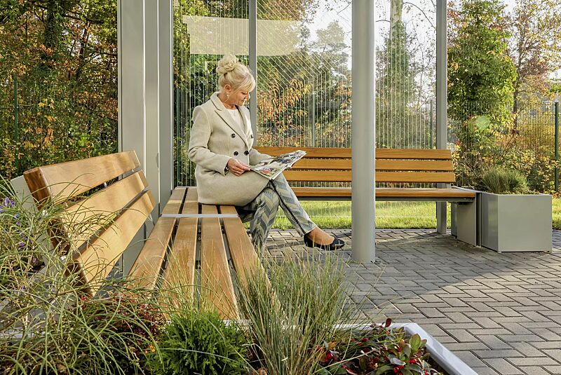 sitzbank-natura__shoKAT0068999 Sitzbank NATURA mit und ohne Rückenlehne, mit Eschenholzbelattung, Windschutzwand PIN SCREEN, Meeting-Point PIN, Pflanzbehälter MALOUT, Stahlkonstruktion in RAL 7046 telegrau