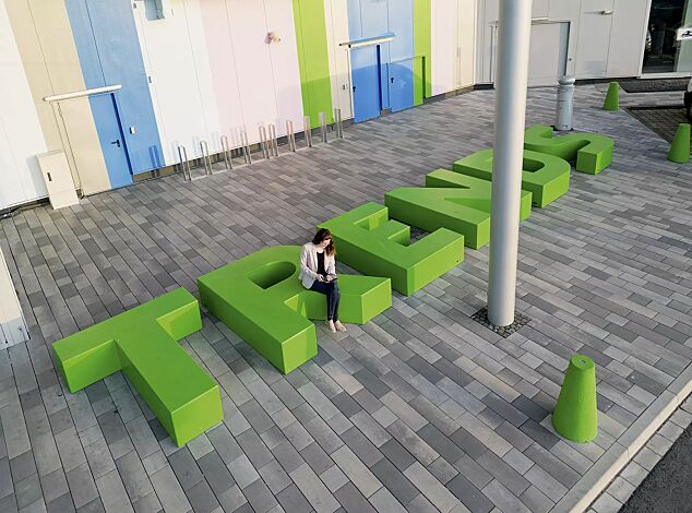 Sitzbuchstaben LETTER LINE in RAL 6037 reingrün sowie Poller KONE