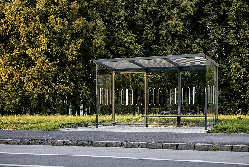 Wartehalle AUREO, Dachbreite x Dachtiefe 4220 mm x 1855 mm, Rück- / Seitenwände ESG Klarglas mit Scheibendekor, Dacheindeckung VSG Klarglas mit Siebdruckstreifen, Sitzbank auftragsbezogen rechts, Stahlkonstruktion in RAL 7016 anthrazitgrauWartehalle AU...