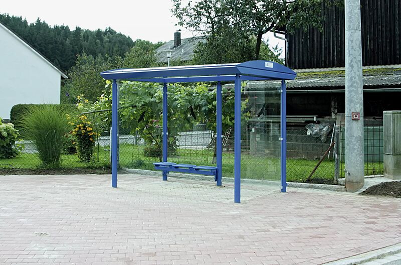 wartehalle-pluto__shoKAT0068529 Wartehalle PLUTO, Dachbreite x Dachtiefe 3300 mm x 2030 mm, mit Rück- / Seitenwänden aus ESG, Klarglas, Drahtgittersitz TARVIS, Stahlkonstruktion in RAL 5017 verkehrsblau