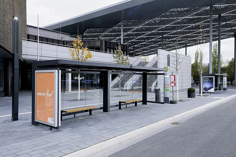 Wartehalle PURE, auftragsbezogene Anpassung der Dacheindeckung aus Stahlblechkassetten, Dachbreite x Dachtiefe 8000 mm x 1800 mm, Rück- / Seitenwand ESG Klarglas mit Siebdruckstreifen, Werbevitrine CITY-LIGHT, Sitzbank PURE, Stahlkonstruktion in DB 703...