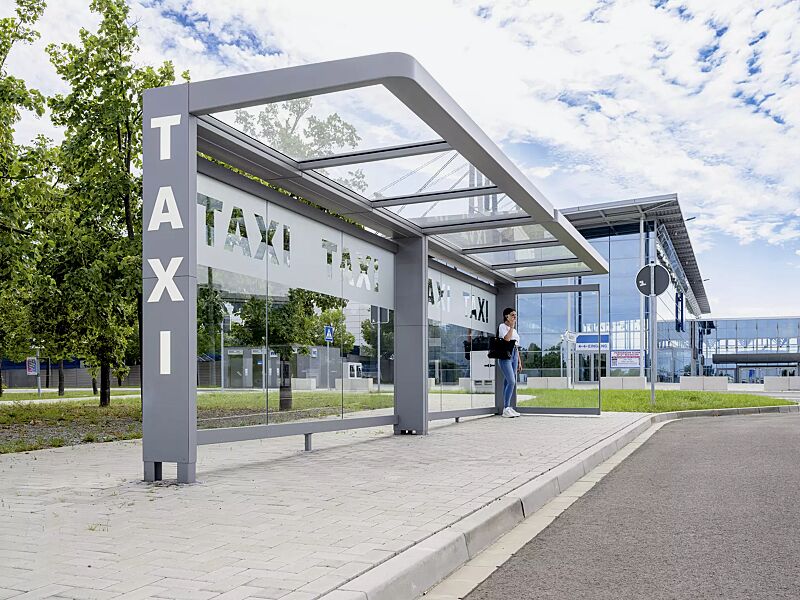 Wartehalle PURE, Dachbreite x Dachtiefe 8000 mm x 1800 mm, Rück- / Seitenwände ESG, Klarglas mit bauseitiger Folierung, Stahlkonstruktion in RAL 7037 staubgrau