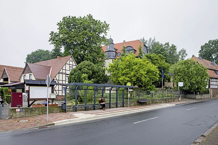 Wartehalle SATURN, auftragsbezogene Anpassung der Dachbreite x Dachtiefe 7060 mm x 1600 mm, inkl. Rückwände ESG, Klarglas, Sitzbänke SESTO und Abfallbehälter HALIFAX, Stahlkonstruktion in RAL 7016 anthrazitgrau