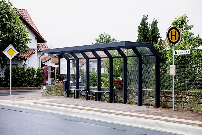 Wartehalle SATURN, auftragsbezogene Anpassung der Dachbreite x Dachtiefe 7060 mm x 1600 mm, inkl. Rückwände ESG, Klarglas, Sitzbänke SESTO und Abfallbehälter HALIFAX, Stahlkonstruktion in RAL 7016 anthrazitgrau