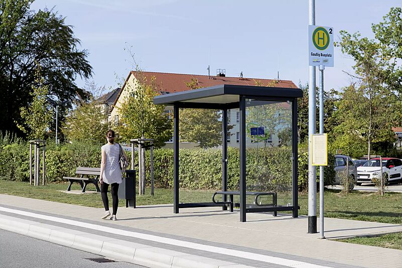 Wartehalle STADT, Dachbreite x Dachtiefe 2520 mm x 1800 mm, mit Rück- / Seitenwänden ESG, Klarglas, Sitzbank SESTO sowie Abfallbehälter HALIFAX, Stahlkonstruktion in RAL 7021 schwarzgrau