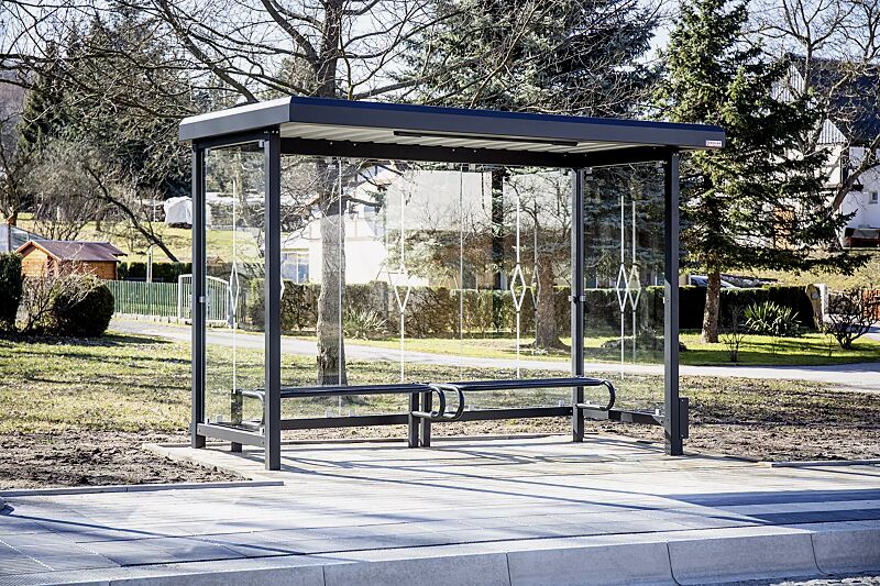 Wartehalle STADT, Dachbreite x Dachtiefe 3620 mm x 1800 mm, Rück- und Seitenwände ESG, Klarglas mit Siebdruckdekor Raute, Sitzbank SESTO, LED-Beleuchtung, Stahlkonstruktion in RAL 7021 schwarzgrau