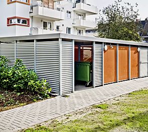 FLEXI-BOX mit auftragsbezogener Anpassung als Kombination Fahrradüberdachung / Wertstoffumhausung, Dachbreite x Dachtiefe 12300 mm x 6300 mm, Wandelemente Lochblech pulverbeschichtet in RAL 2003 pastellorange bzw. Aluminiumwellblech, <font size="2" face="Helvetica">Drehflügeltür, einflügelig</font> mit Aluminiumwellblech, Stahlkonstruktion feuerverzinkt, Dachattika in RAL 9007 graualuminium